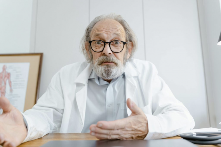 A focused physician studying at a desk with medical books, notes, and a laptop, preparing for the Qualified Medical Evaluator (QME) Exam. The image represents dedication, exam readiness, and structured study strategies for passing the QME exam.