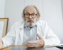 A focused physician studying at a desk with medical books, notes, and a laptop, preparing for the Qualified Medical Evaluator (QME) Exam. The image represents dedication, exam readiness, and structured study strategies for passing the QME exam.